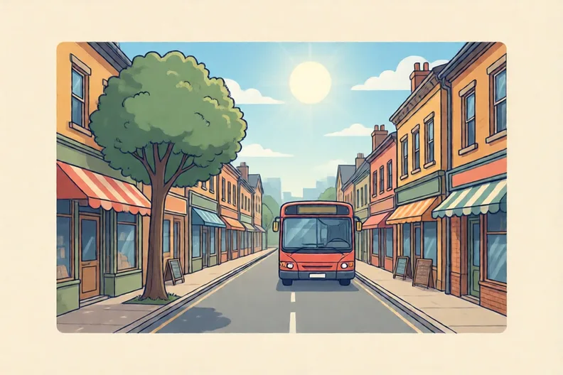 A town street with shop fronts, a bus and a tree by the pavement