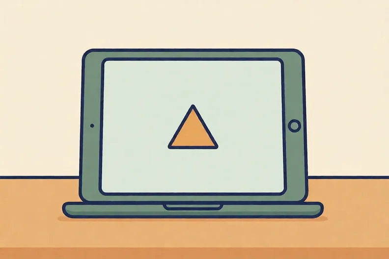 A tablet on a desk showing a small triangle on a plain screen