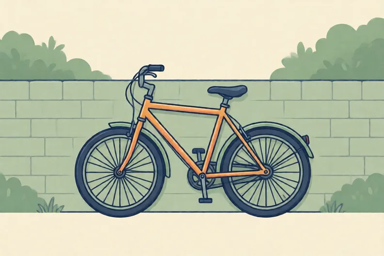 A bicycle leaning against a garden wall, with its wheels and pedals visible