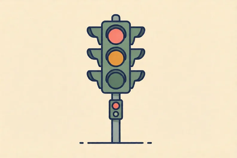 Traffic lights beside a quiet road crossing, with a push button on the pole