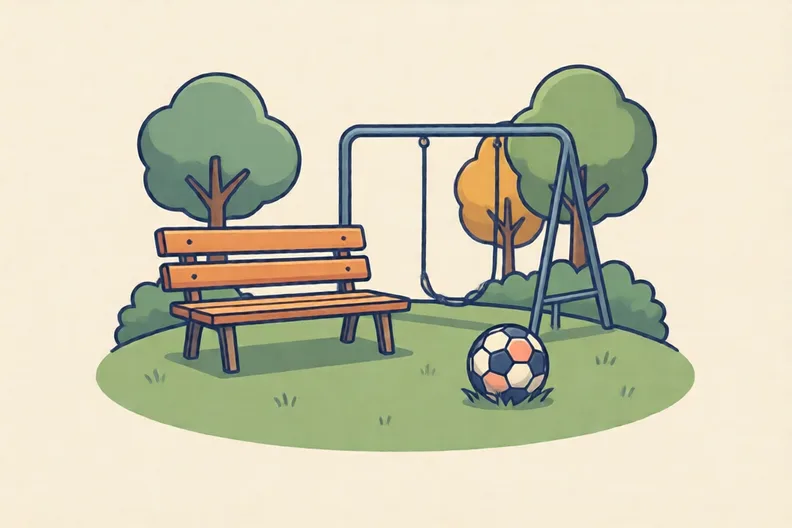 A quiet school playground with a bench and a football, no people