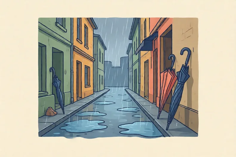 A rainy street with puddles and closed umbrellas, no people