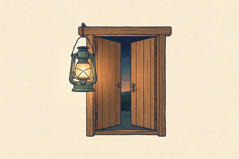 A lantern hanging beside an open wooden doorway at dusk
