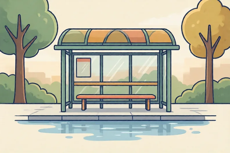 A quiet bus stop on a wet street with an empty bench and a timetable board