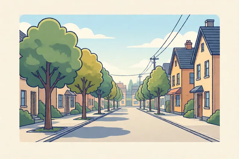 A quiet town street with young trees along the pavement and no people