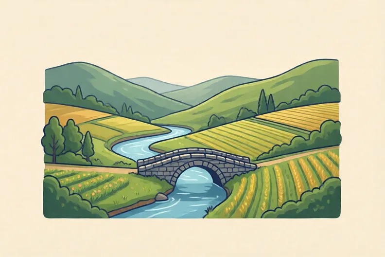 A green valley with a river running through it, a stone bridge and small fields