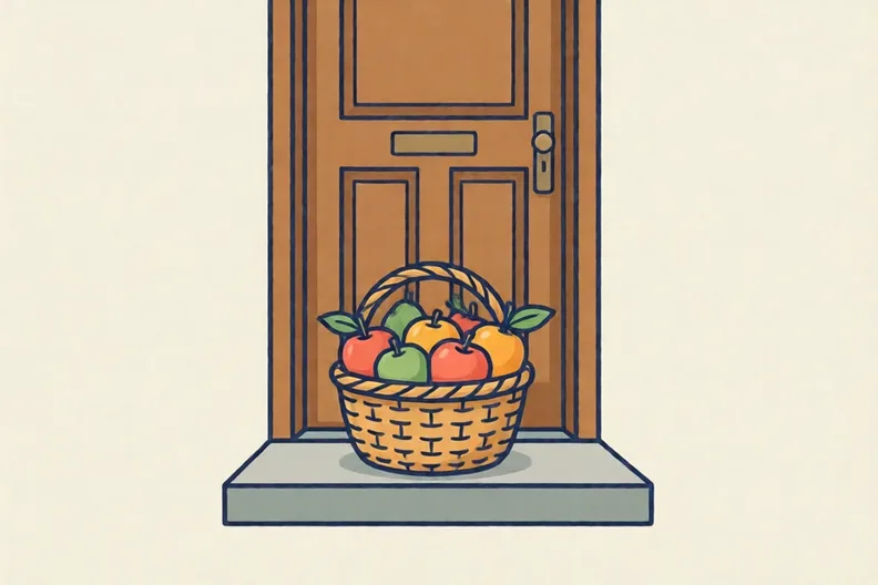 A basket of fruit sitting on a doorstep in front of a closed door.