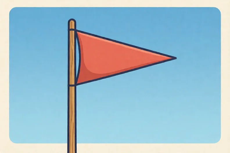 A triangular red pennant flag flying from a tall wooden pole against a blue sky
