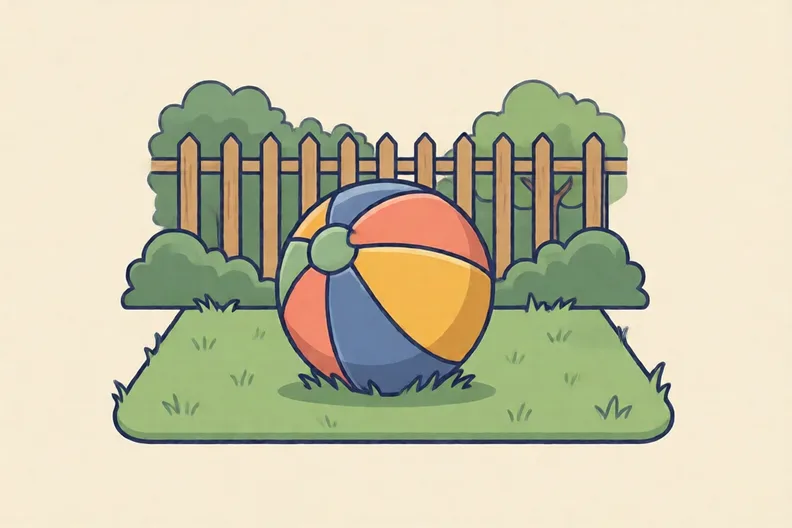 A soft ball on a patch of grass in a back garden, with no people