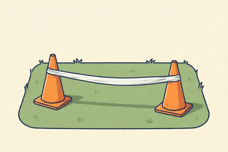 A strip of white tape stretched across a short green lawn between two orange cones
