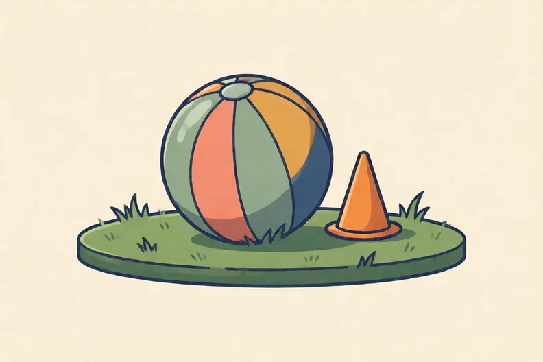 A soft ball resting on a garden lawn beside a small orange cone