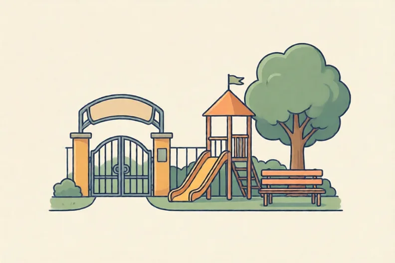 A school gate and playground with a bench and a tree