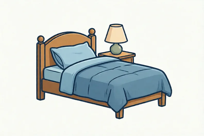 A neatly made bed beside a bedside table with a switched-off lamp.