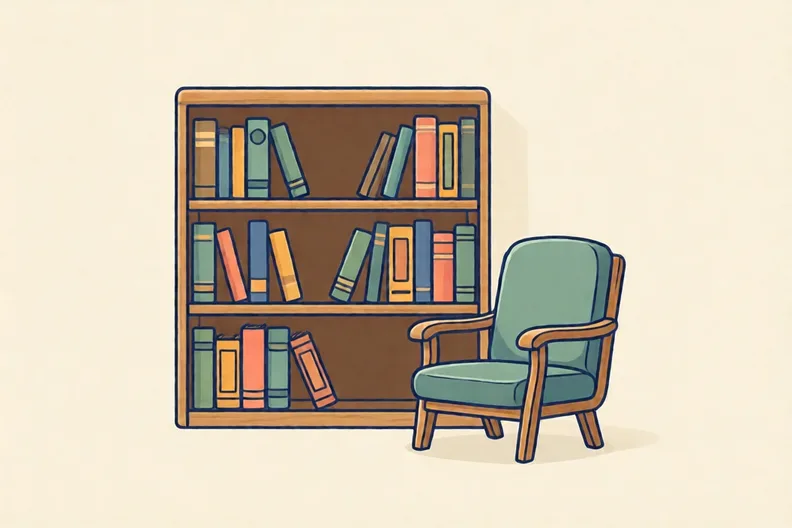 A library shelf with rows of books and a reading chair
