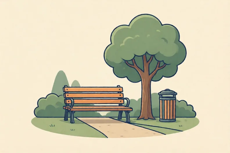 A quiet park with a bench beside a path and a tall tree