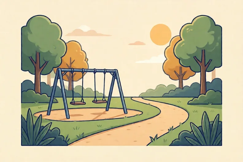 An empty playground swing set in a park on a sunny afternoon, no people