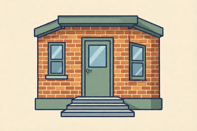 The front door of a plain brick hostel with a step