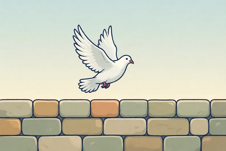 A white dove flying over a plain stone wall under a pale sky