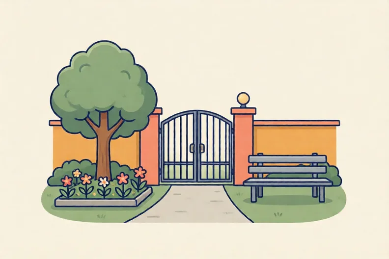 A school gate with a small tree, a flower bed and a bench